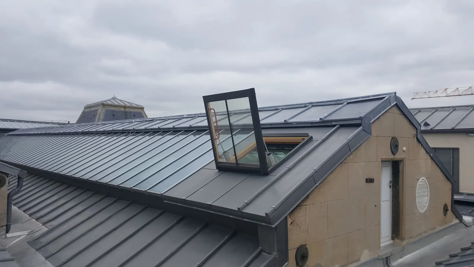 Châssis de désenfumage électrique ouvert sur une toiture en zinc