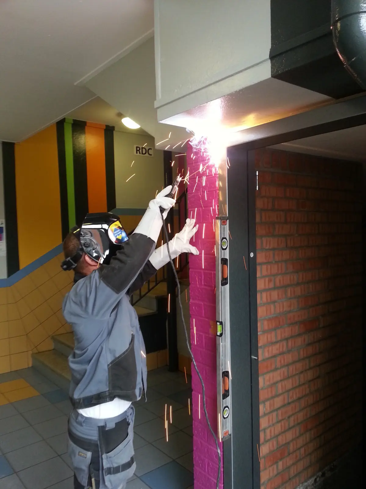 Soudure des pattes de scellement d'une huisserie de porte blindée